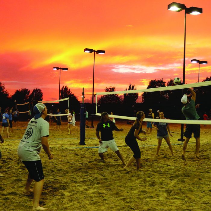KC Crew leagues playing sand volleyball at sunset