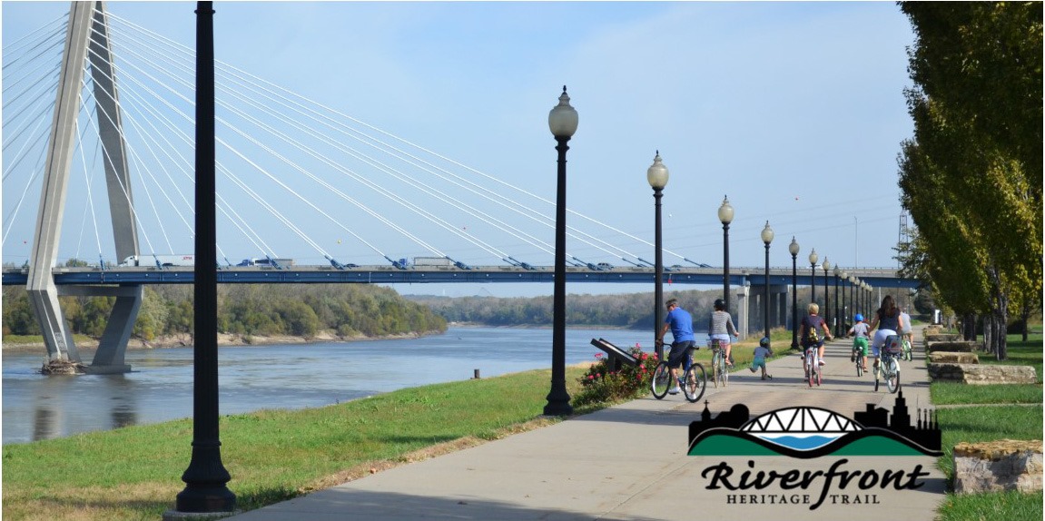 family biking down the riverfront heritage trail
